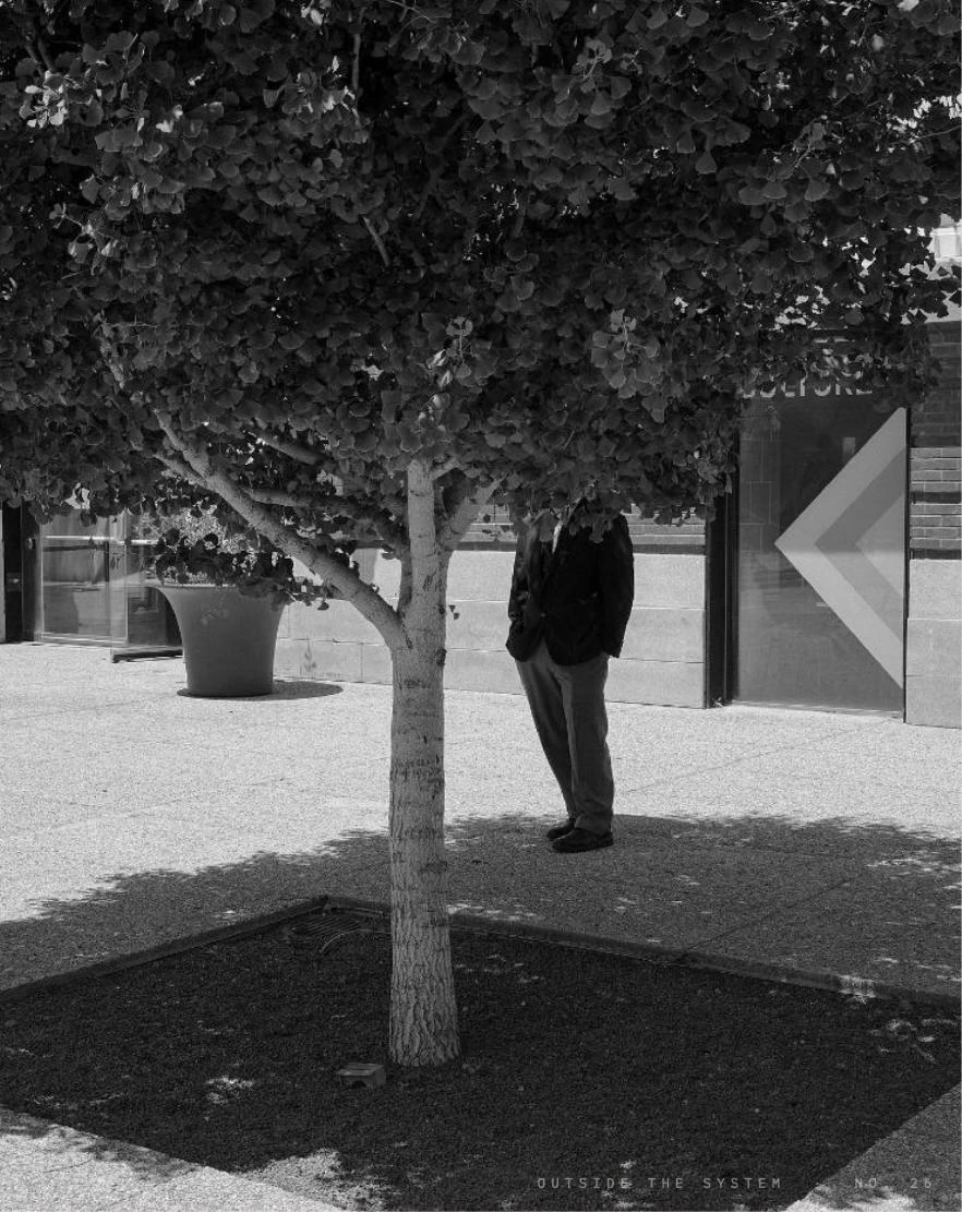 A man standing beneath a tree, photographed by Dan Kutler